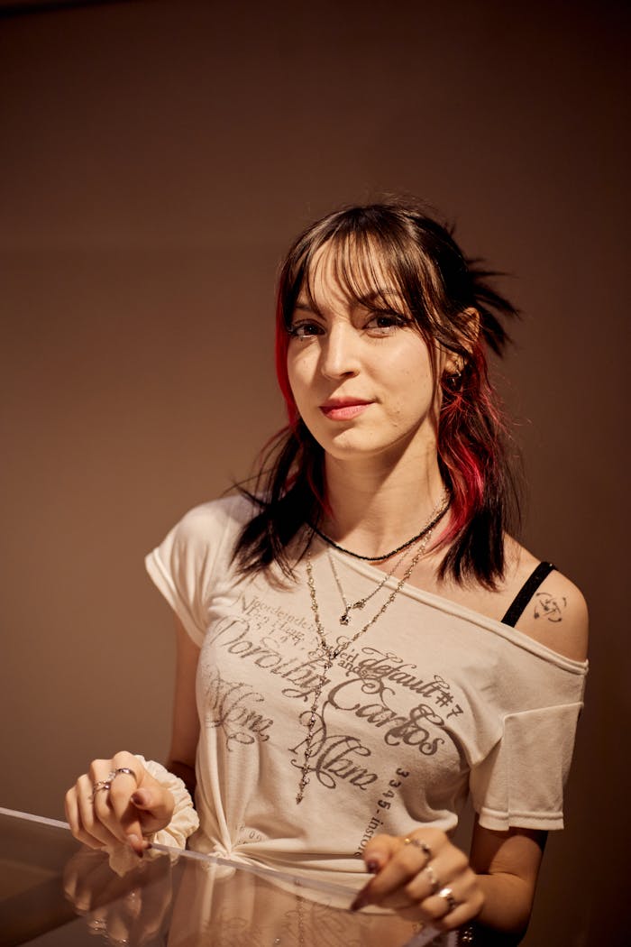 Portrait of a young woman with layered necklaces and casual attire in İstanbul.