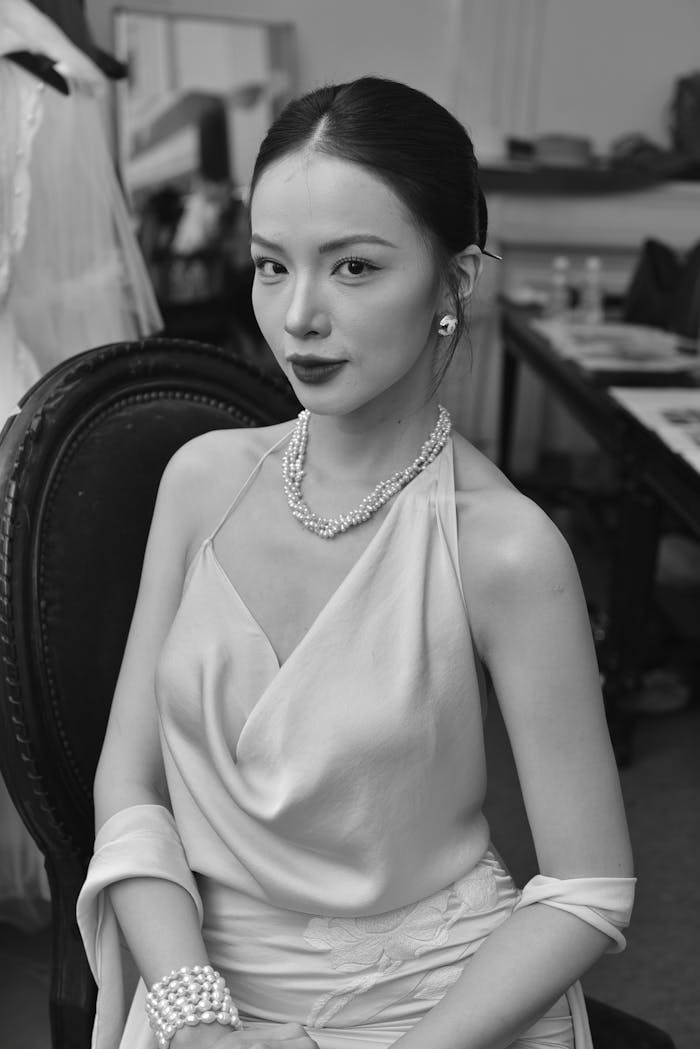 A sophisticated portrait of an elegant woman in a gown, adorned with pearls.
